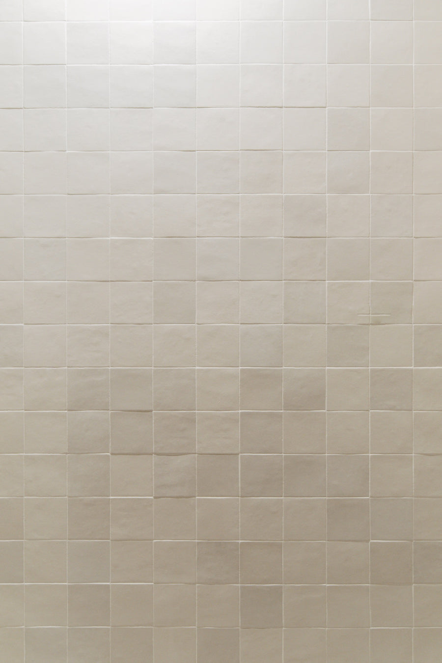 Cream square zellige tile set in a straight stacked grid on a wall in Clive, with thin white grout lines.