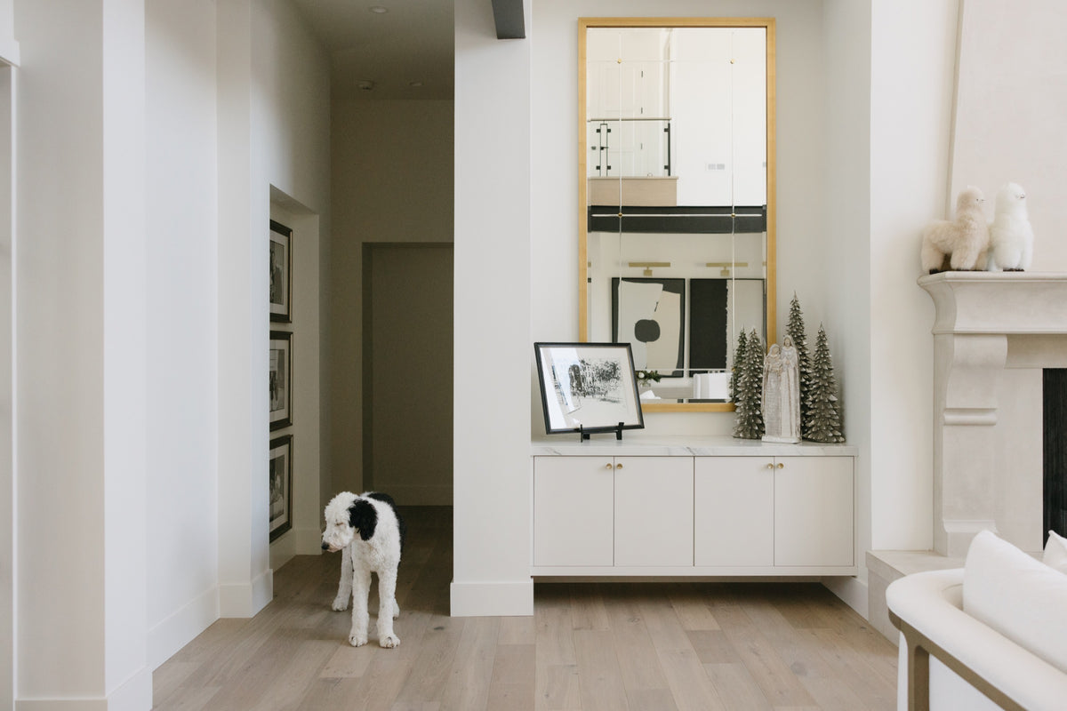 An entry in West Des Moines with a floating white console under an oak framed mirror, topped in marble.