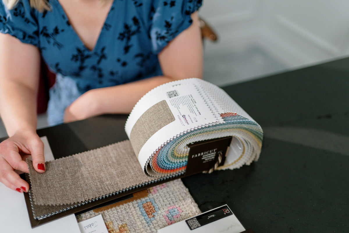 A fabric sample book open to a heathered oatmeal linen during a design meeting in Waukee.