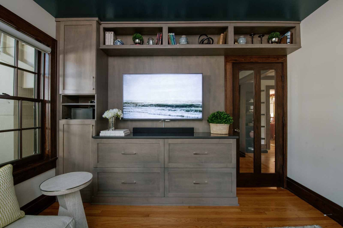 A living room in Des Moines with gray stained built-in cabinets under a glossy deep teal ceiling.
